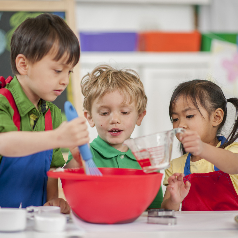 Three children stirring something in a bowl