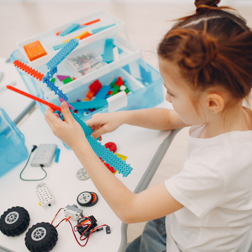 Girl building something with wheels