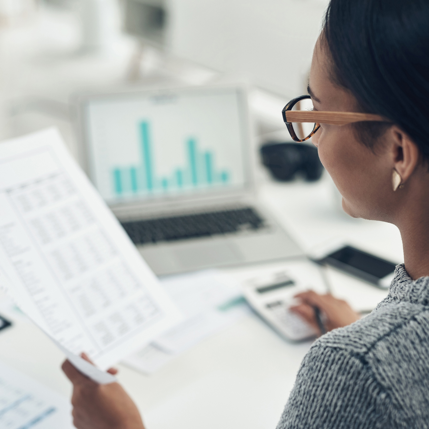 Person wearing glasses examining financial document