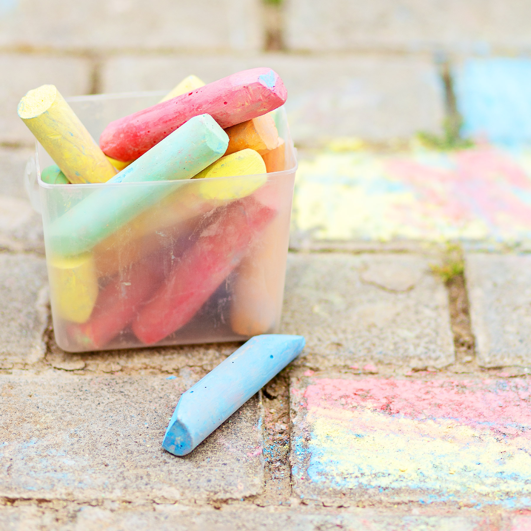 chalk in a variety of colors on brick path