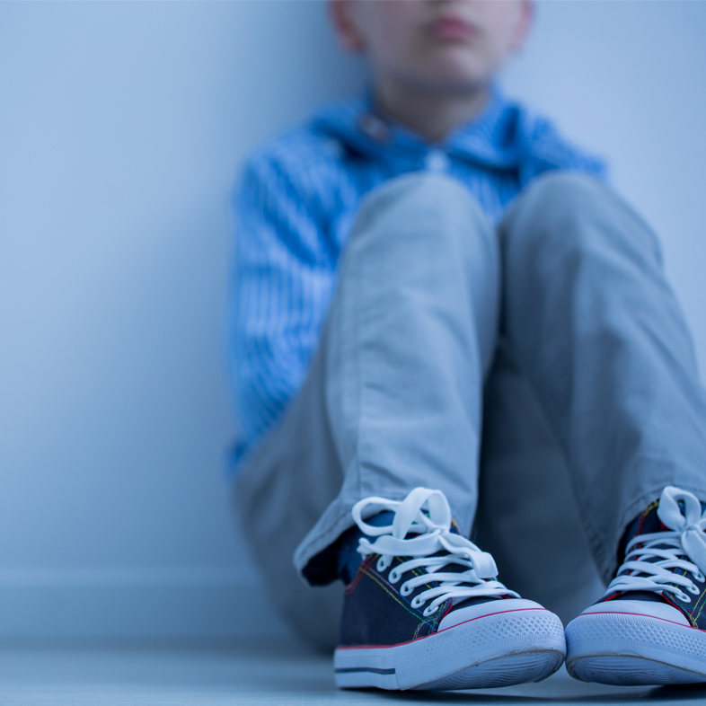 Sad child sitting on floor