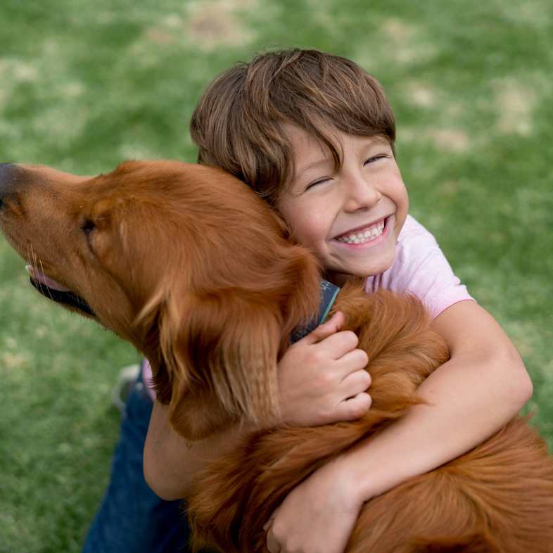 Child hugging a dog