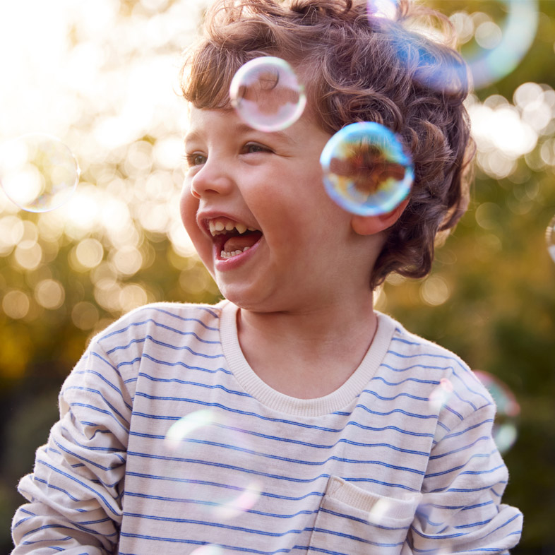 Young boy laughing with bubbles