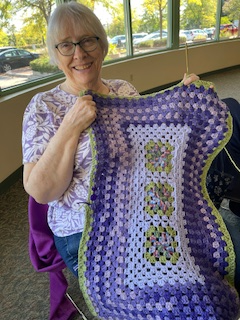 Woman holding a crocheted afghan