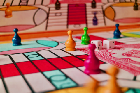 A pink hued, colorful board with colorful cone shaped pieces on top 