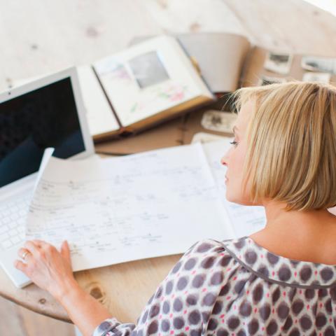 Woman reading documents at a computer