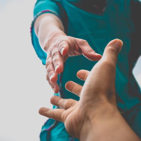 People reaching out to hold hands