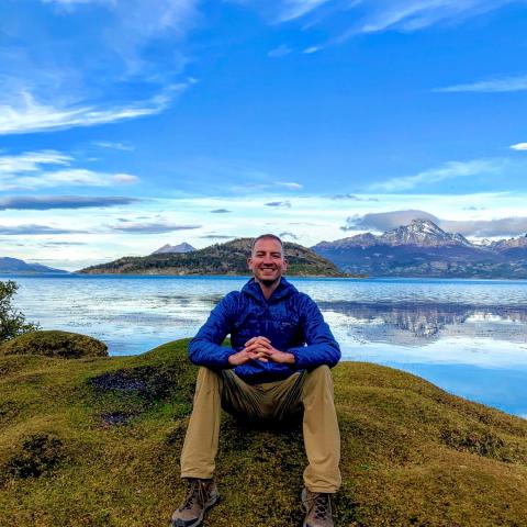 Brian Michalski sitting on a mountain top