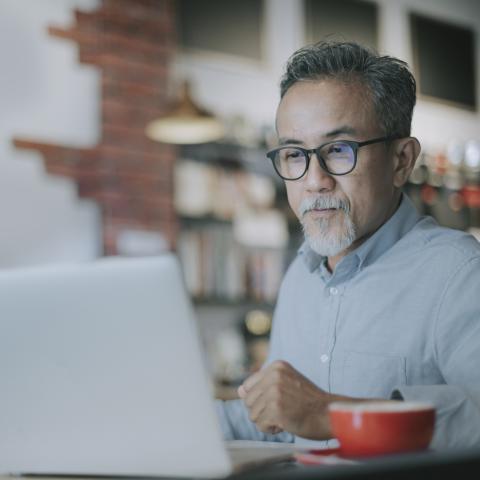 Man on computer with a cup of coffee