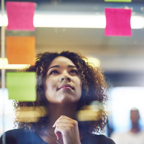 Woman looking up at sticky notes on a wall