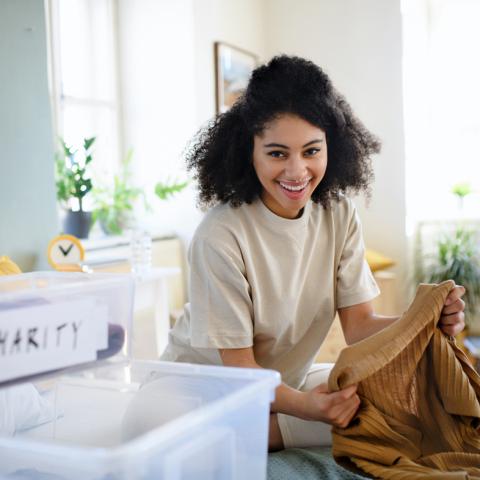 woman placing shirt in a bin