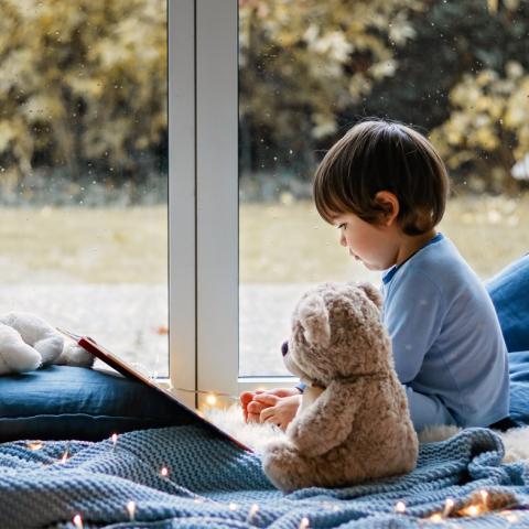 Toddler reading story in pajamas