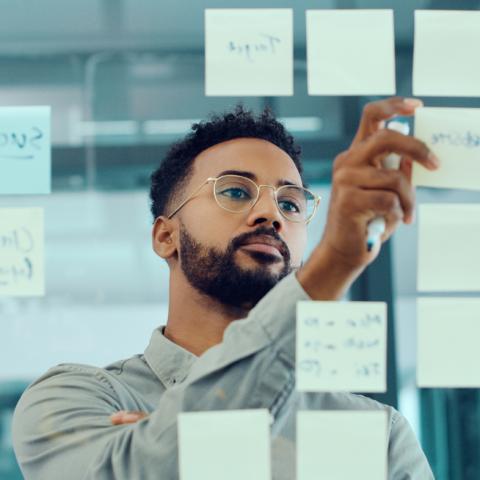 Young businessman brainstorming with sticky notes