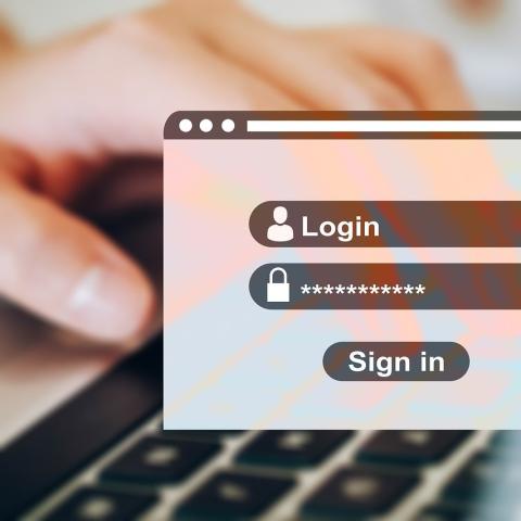 computer window for login with hand on keyboard in background