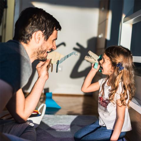 Dad and daughter playing with puppets