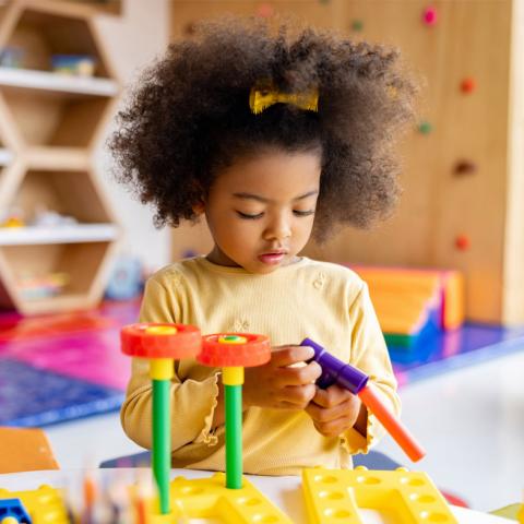 Young girl playing with building blocks