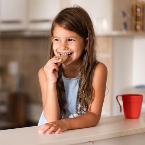 Girl eating a chocolate cookie