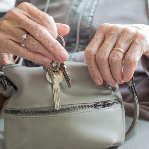 Older woman's hands taking keys from purse