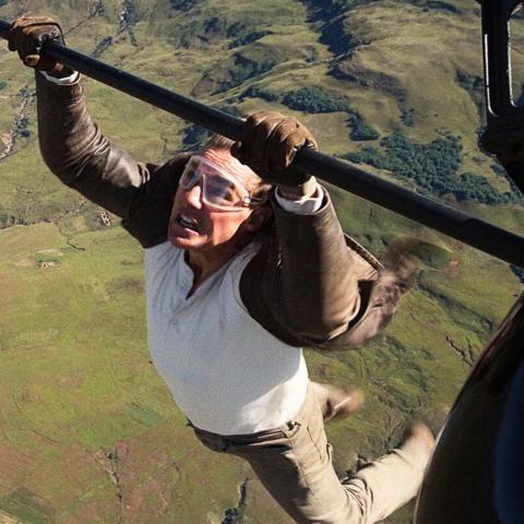 Actor Tom Cruise hanging from wing of small plane