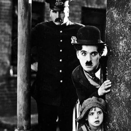 Actor Charlie Chaplin and cast members in classic comedy film