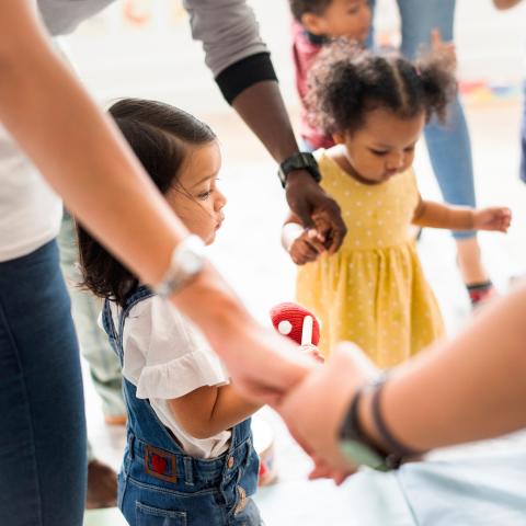 children holding hands with caregivers