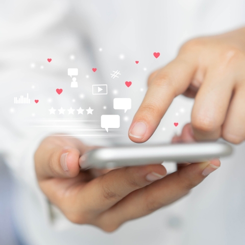 hand scrolling on phone with social media icons popping up