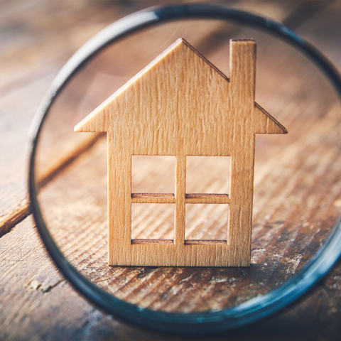 Wood house under magnifying glass