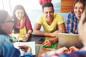 Teen boys and girls sitting at a table talking