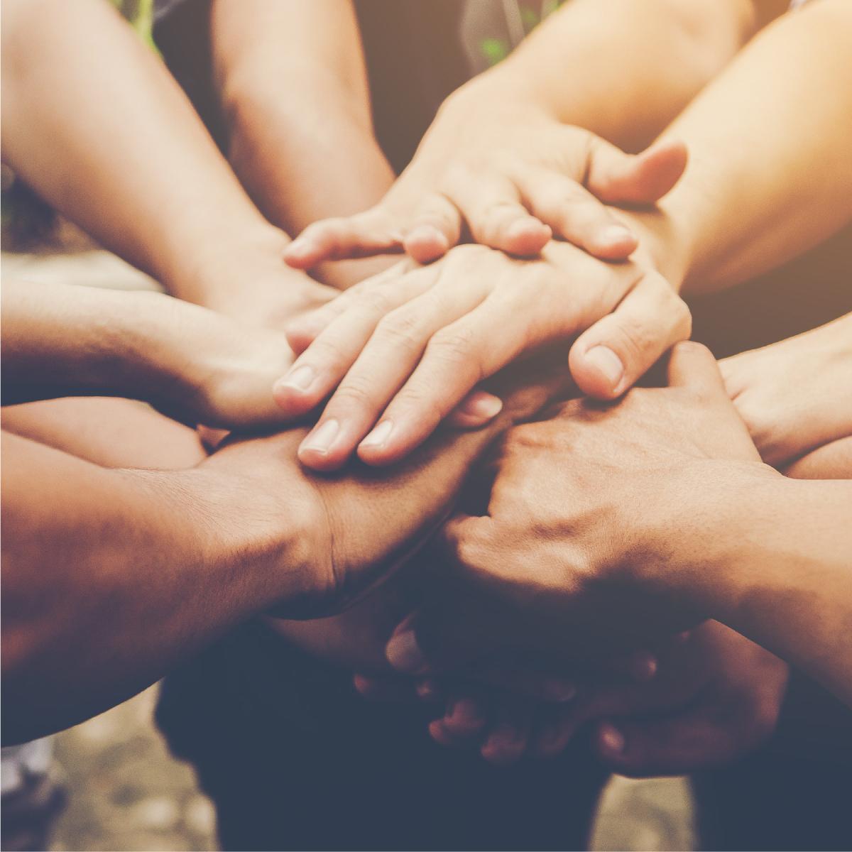 Group in a circle with hands in the middle