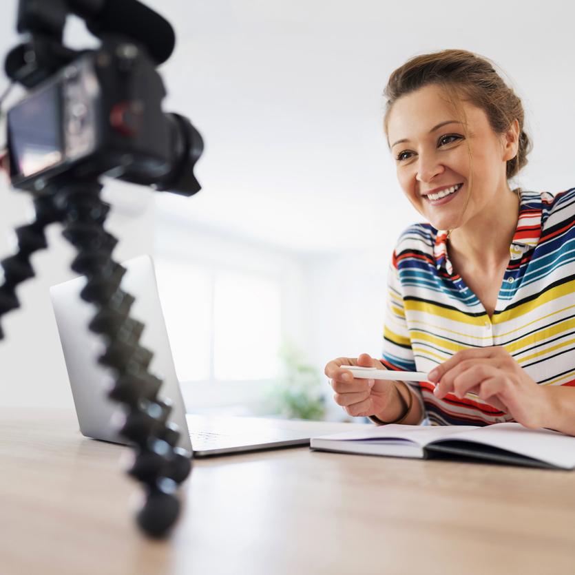 Person at a table speaking to a camera