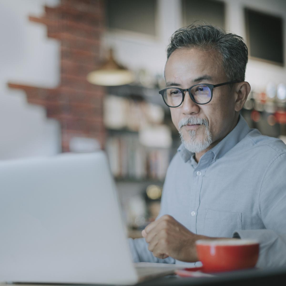 Man on computer with a cup of coffee