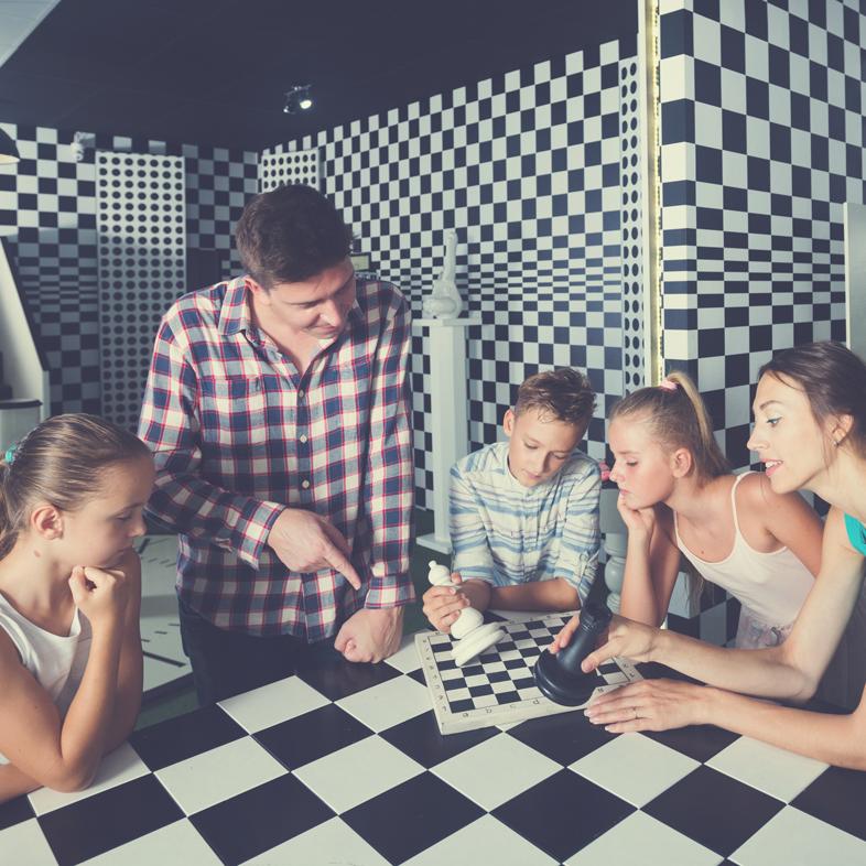 Group of teens and adults solving a puzzle in an escape room