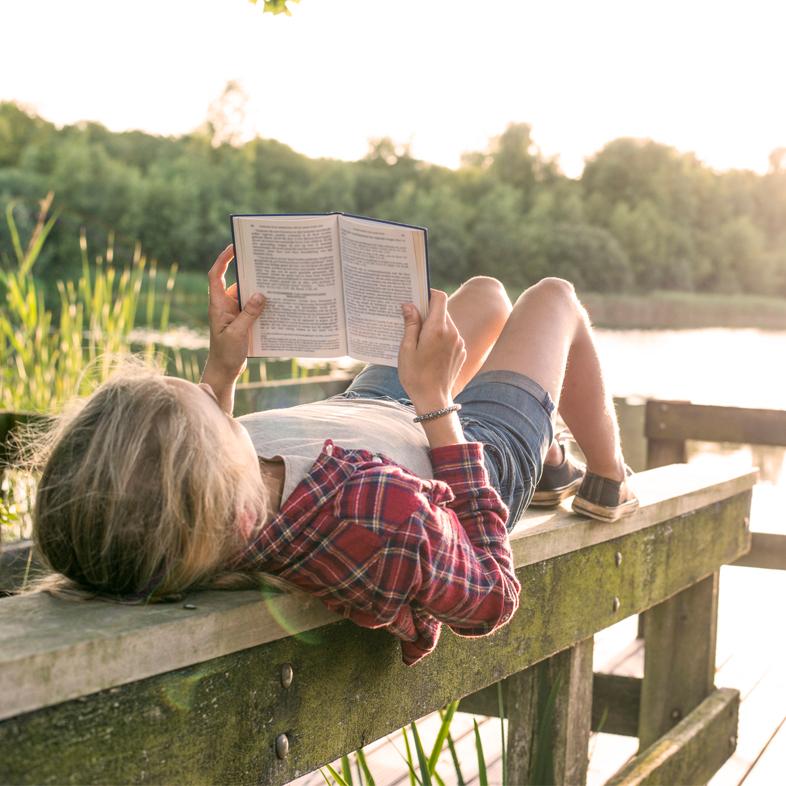 Child reading while laying down outside