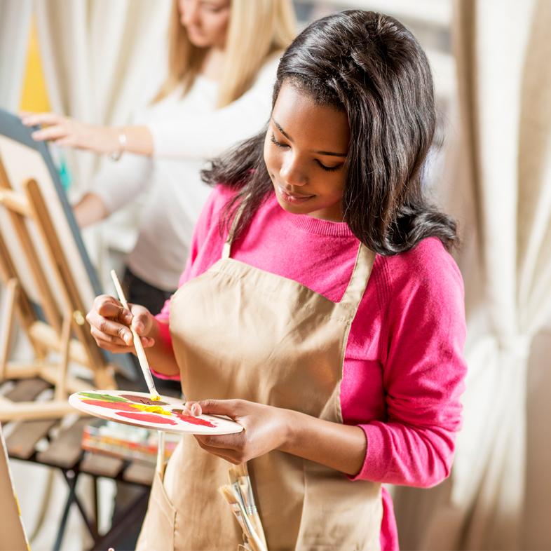 Teen girl painting on easel