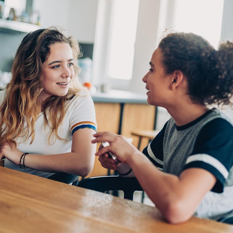 Two teen girls playing a card game