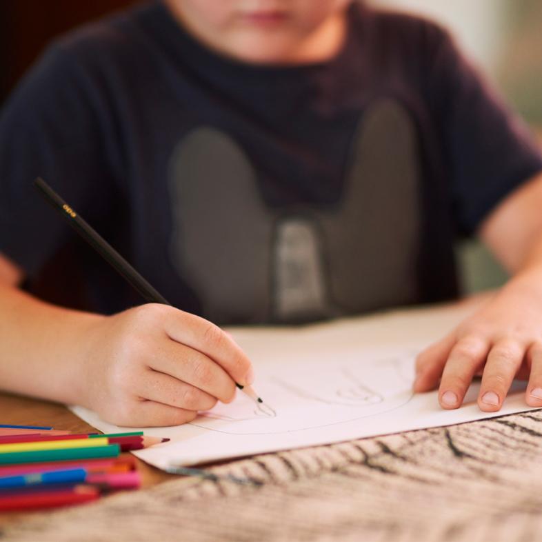 Child drawing with colored pencils