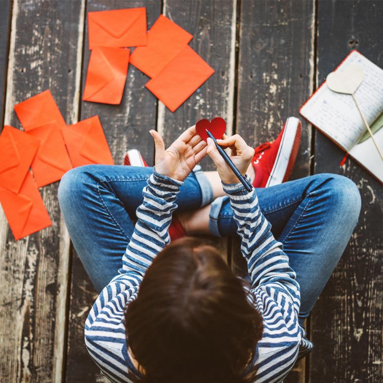 Teen sitting surrounded by valentines day cards