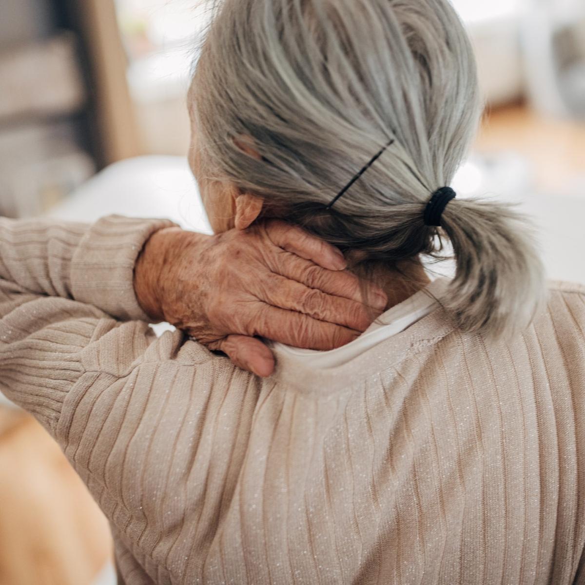 Older woman rubbing neck