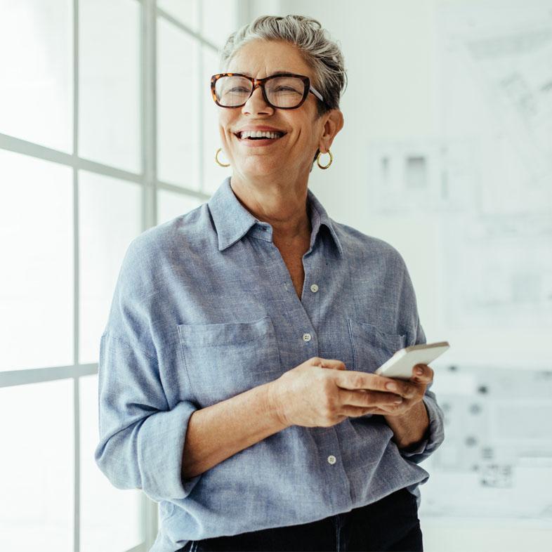 Women smiling looking up from phone