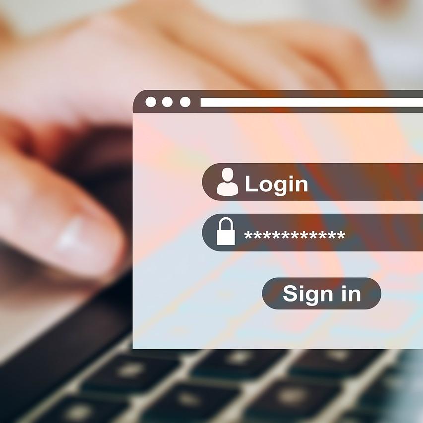 computer window for login with hand on keyboard in background