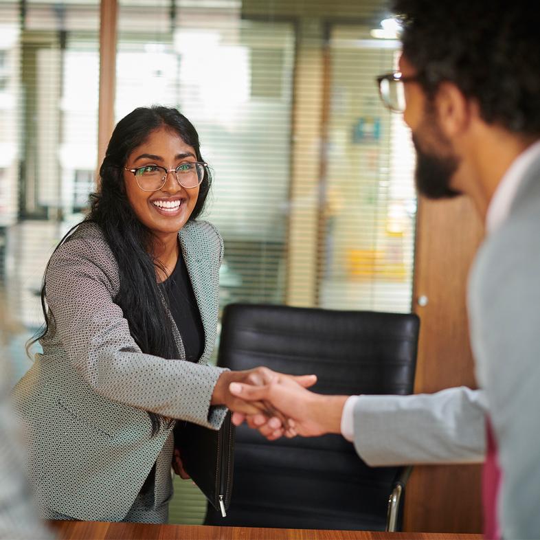 Two people shaking hands before an interview
