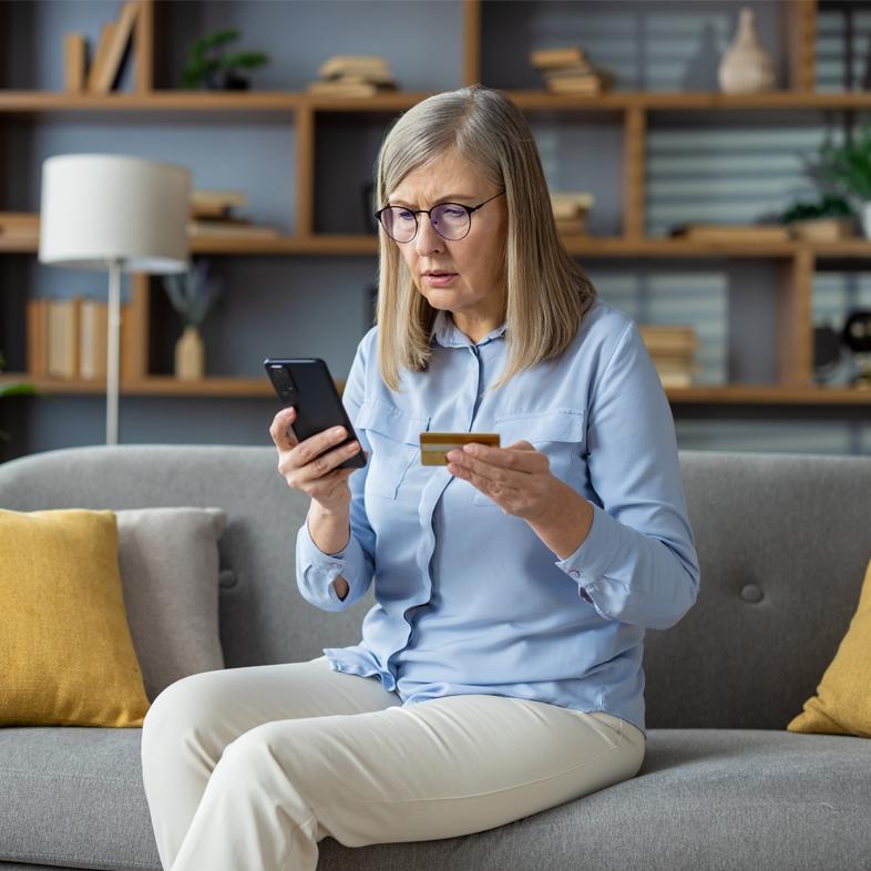 Senior woman looking worried at credit card