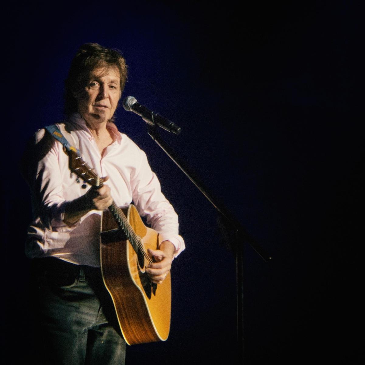 Paul McCartney performing with guitar