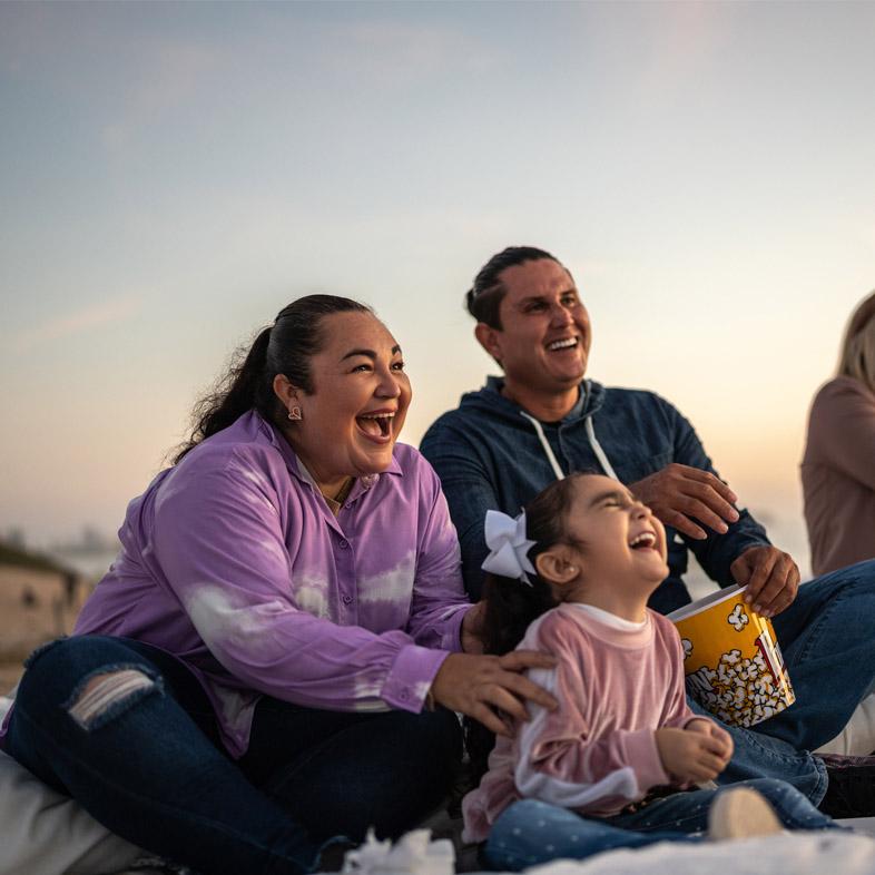Family outside on a blanket laughing