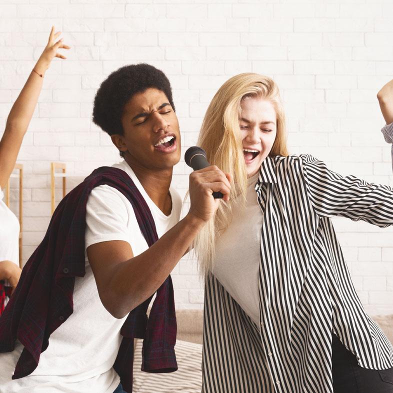 Teens singing into microphone