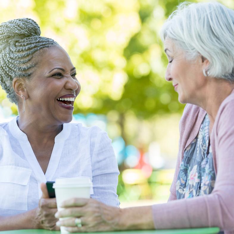 Two senior women having a discussion at a table