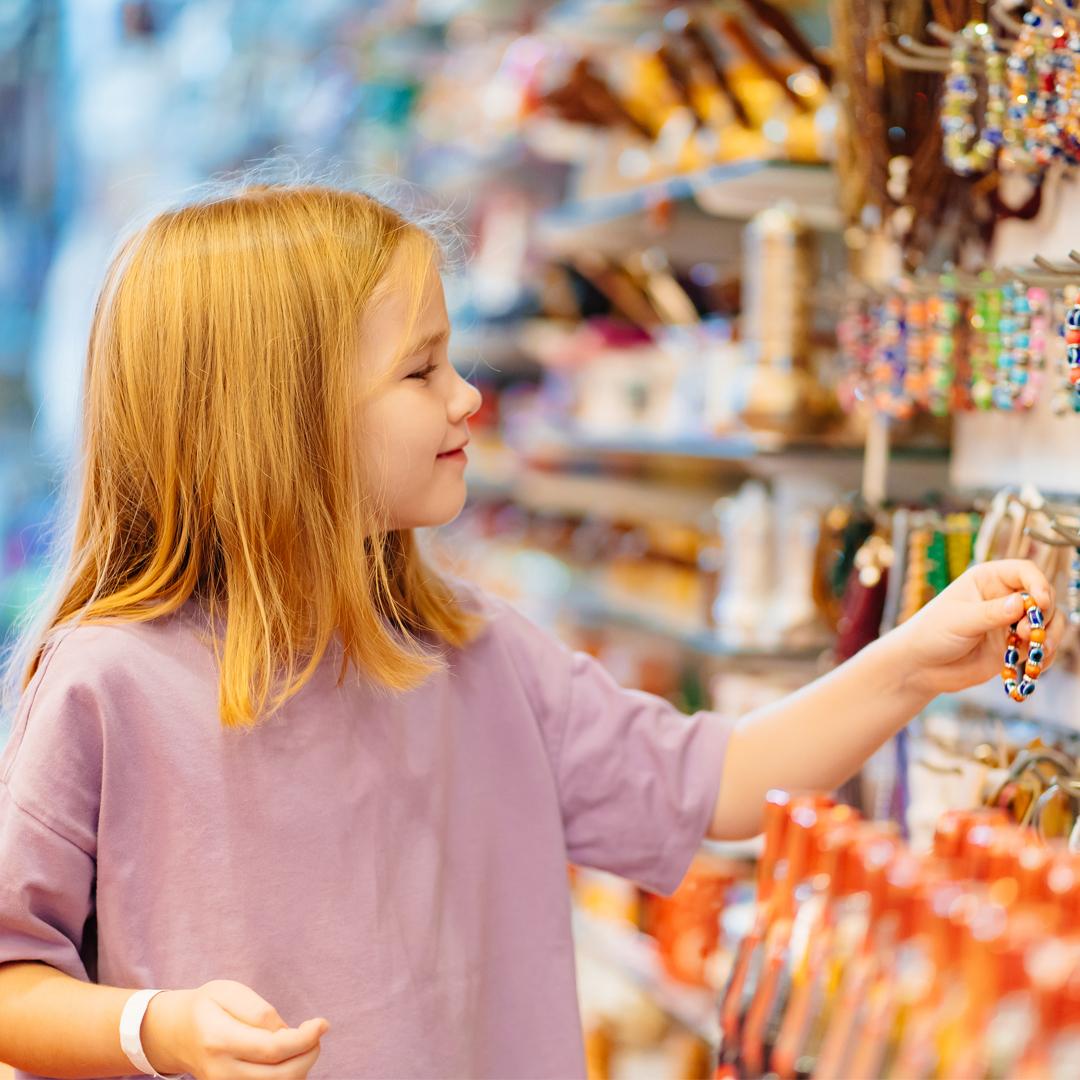 Young girl looking at beaded bracelets