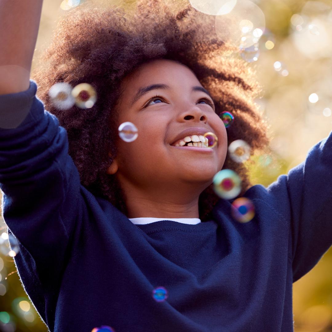 Boy looking up playing with bubbles