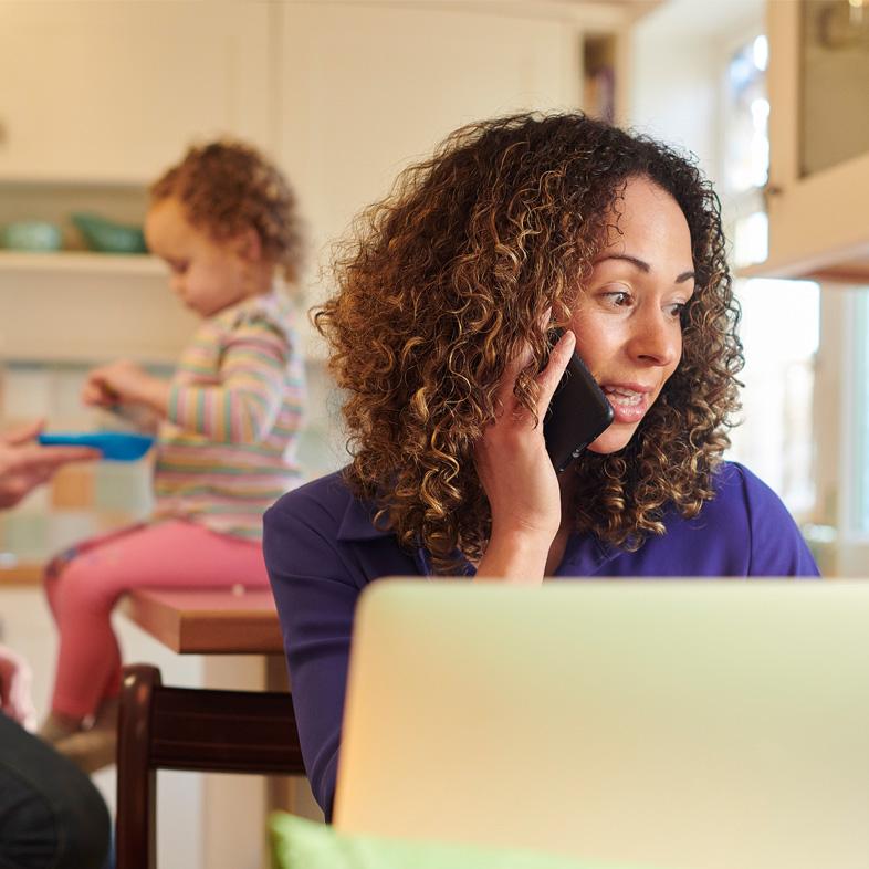 Woman on phone with daughter in background