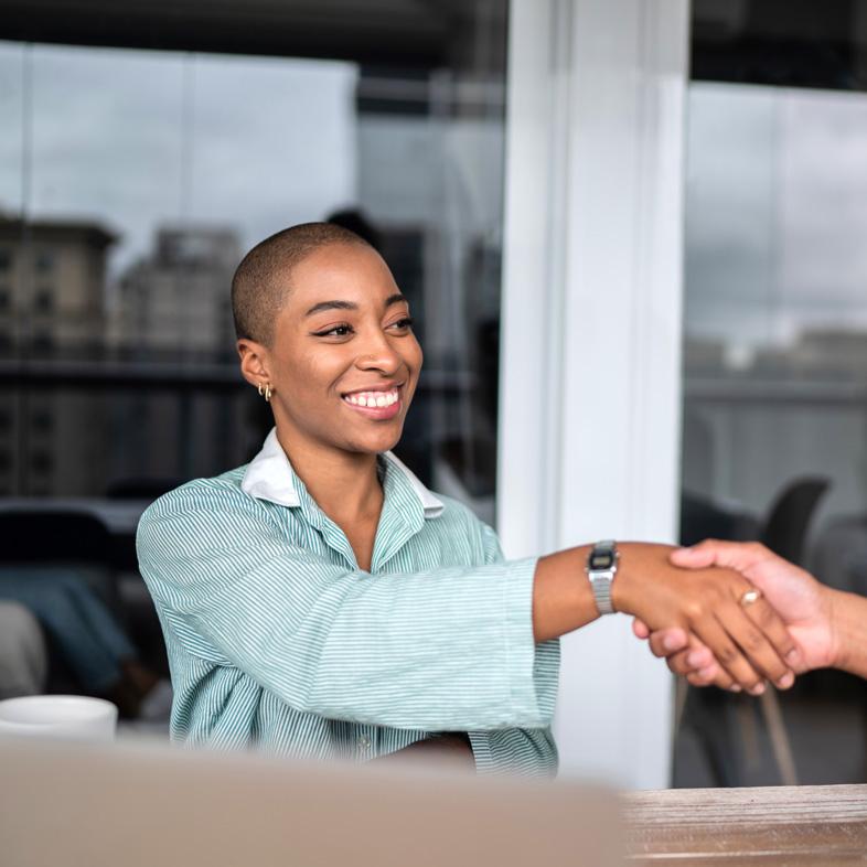 Woman smiling shaking someone's hand